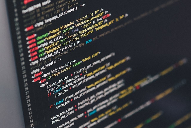 Persona trabajando en un portátil con código en la pantalla, simbolizando sistemas